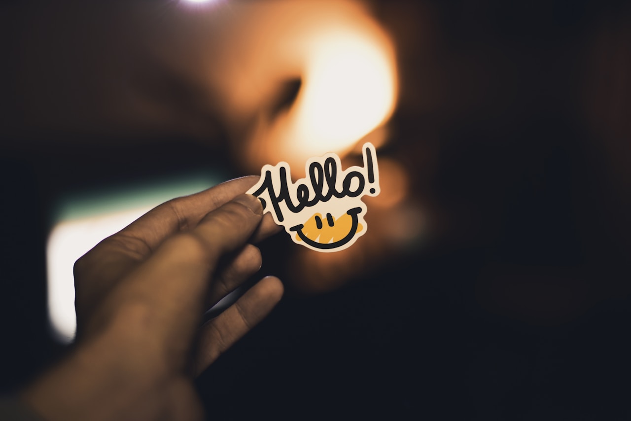Person holding a hello sticker